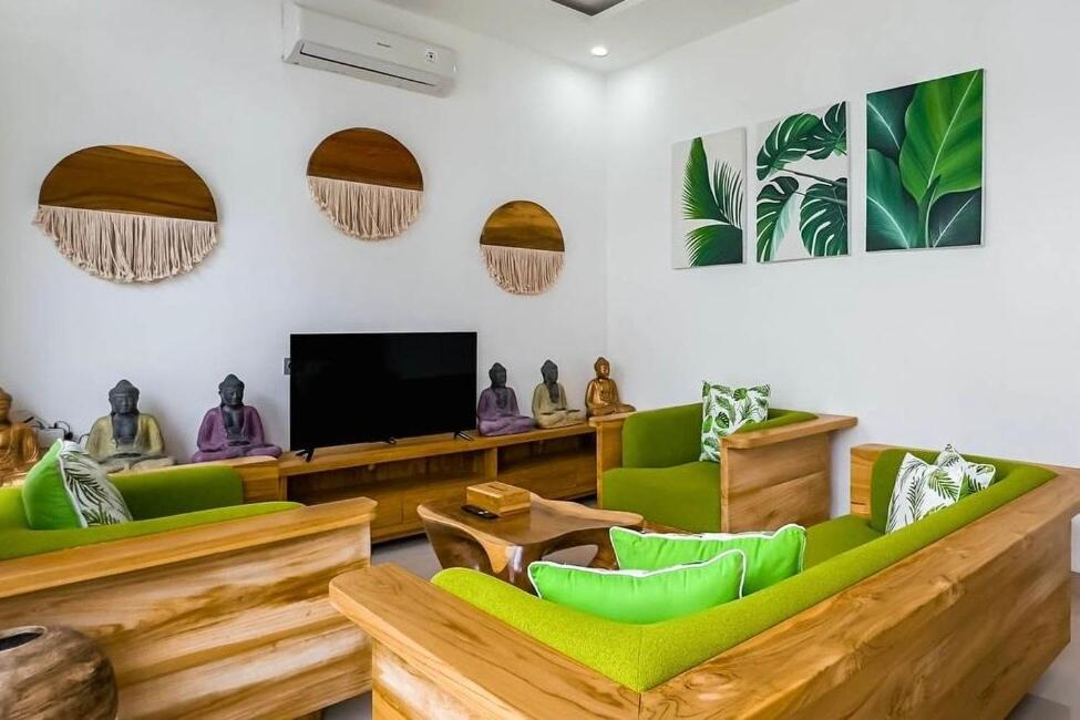 a living room with green chairs and a flat screen tv at Luxurious Semeniyak new 2BR villa with a pool in Seminyak