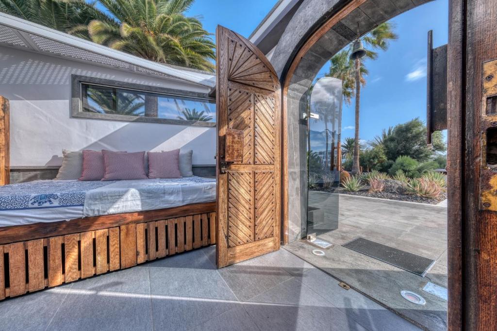 a bedroom with a bed and a glass door at Casita Malvika - Luxury and Sea view - 1min to the Beach By Lanzarote Vacation Homes in Costa Teguise
