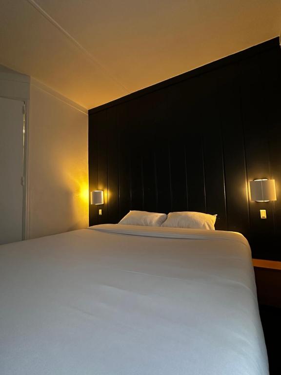 a bedroom with a large white bed with two pillows at Fasthotel Laval in Laval