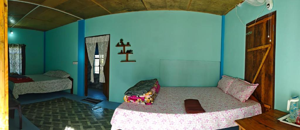 Arman homestay mawlynnong في Mawlynnong: غرفة نوم بسرير في غرفة بجدران زرقاء