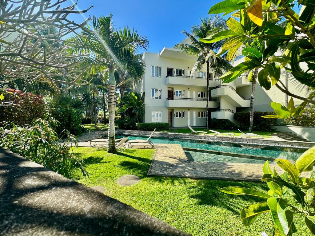 Cape Bay by AAA Rentals - Cap Malheureux في كاب مالهيريوكْسْ: منتجع مع حمام سباحة وأشجار النخيل