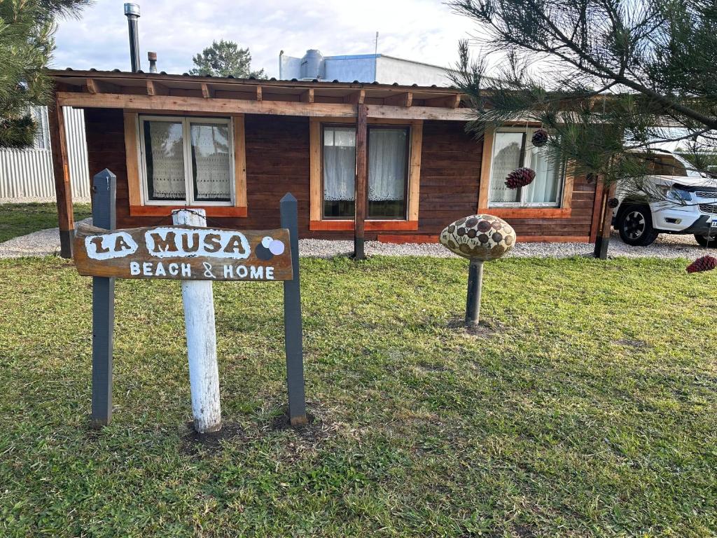 San Eduardo del MarCasa en playas del sur de mar del plata, la musa beach and home的房子前草地上的标志