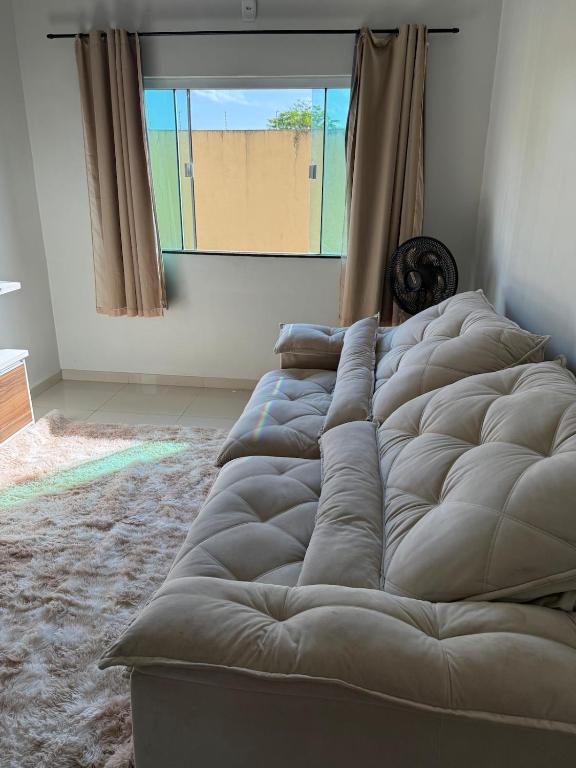 uma cama grande em um quarto com janela em Casa completa com dois quartos e uma suíte master, localizada no bairro Alphaville Fazendinha em Macapá