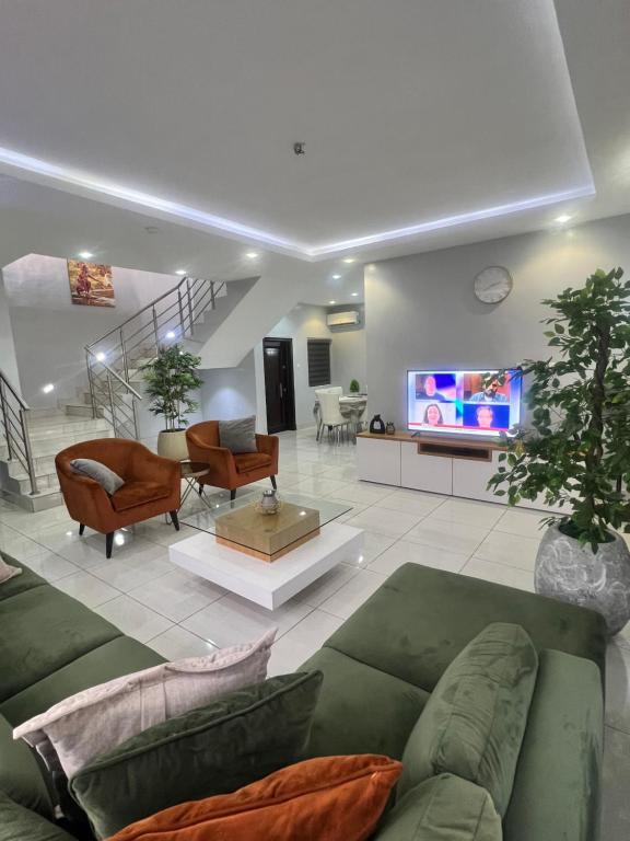 a living room with a couch and a tv at Lekki holiday shortlet in Lekki