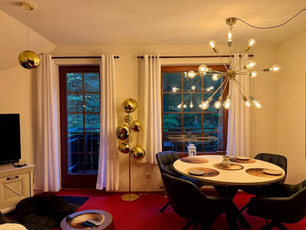 a dining room with a table and a chandelier at Harztastisch Ferienwohnung in Bad Sachsa