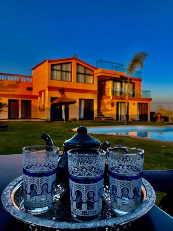 three blue and white glasses on a tray with a house at Tynass Ferme - Fes in Fez
