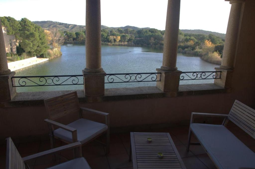 a balcony with chairs and a view of a river at Appartement Pont Royal vu lac in Mallemort
