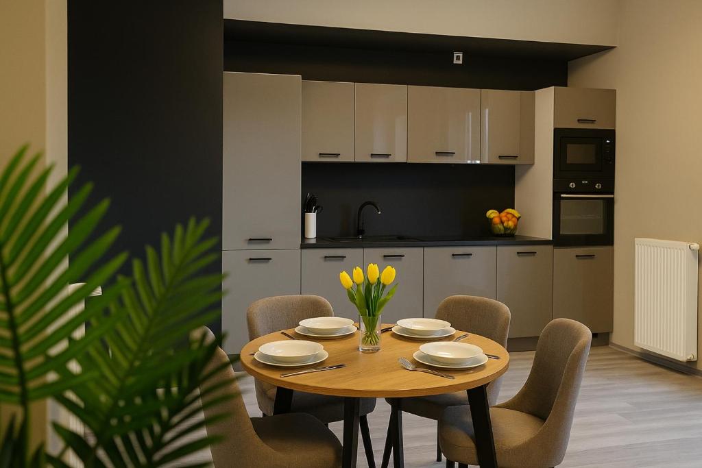 eine Küche mit einem Holztisch mit Stühlen und einem Esszimmer in der Unterkunft Stadtzentrum Apartment - Modern & Ruhig in Quakenbrück