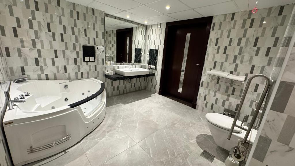 ein Badezimmer mit Badewanne, Toilette und Waschbecken in der Unterkunft Quiet Dreams - Serviced Apartments King abdul Aziz Street Branch in Dschidda