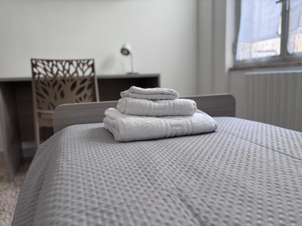 3 asciugamani sono impilati sopra un letto di Salerno a due passi dal mare a Salerno