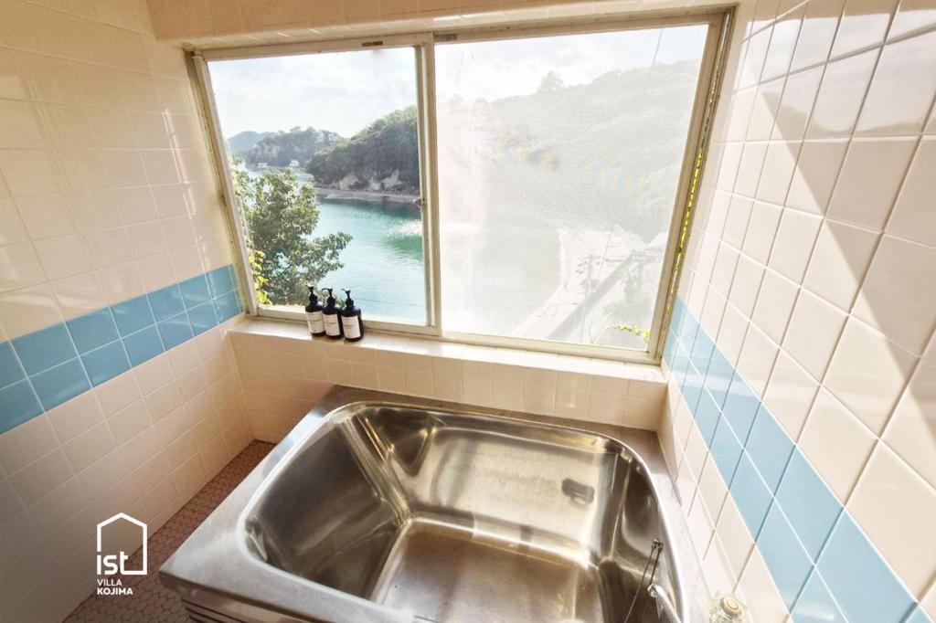 Bizenist villa 10 Retro Seaside Sleeps 5的带窗户的浴室内的盥洗盆