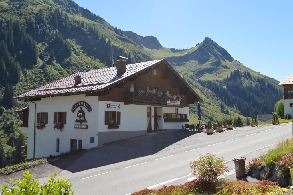 a building on the side of a road with a mountain at Gasthaus Glöckle in Damuls
