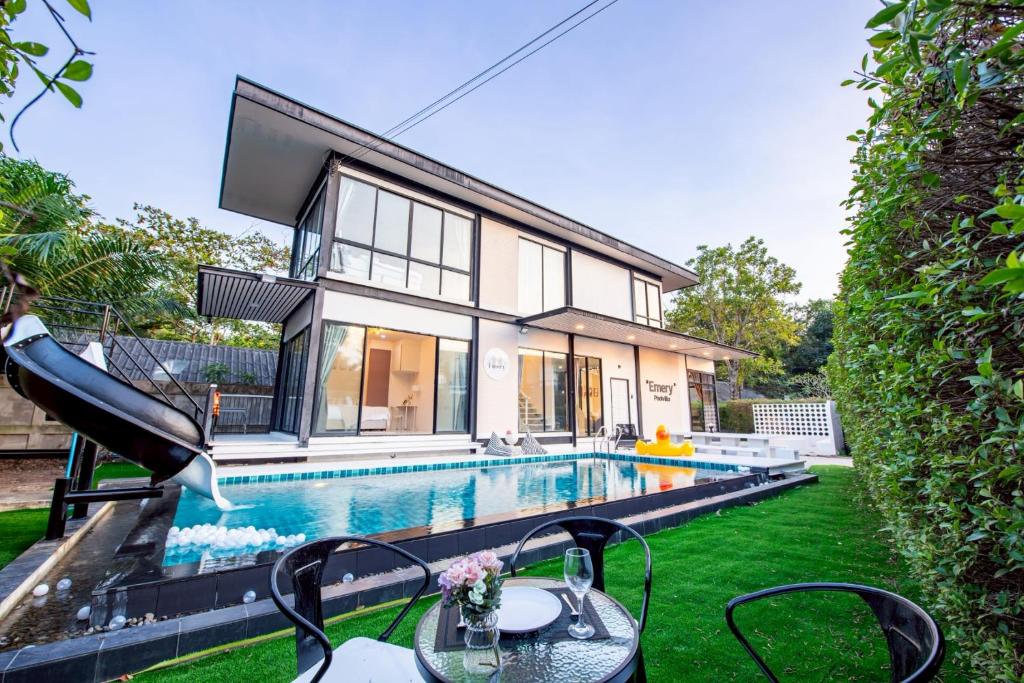 a home with a swimming pool and a house at Emery Pool Villa Pattaya in Ban Huai Yai