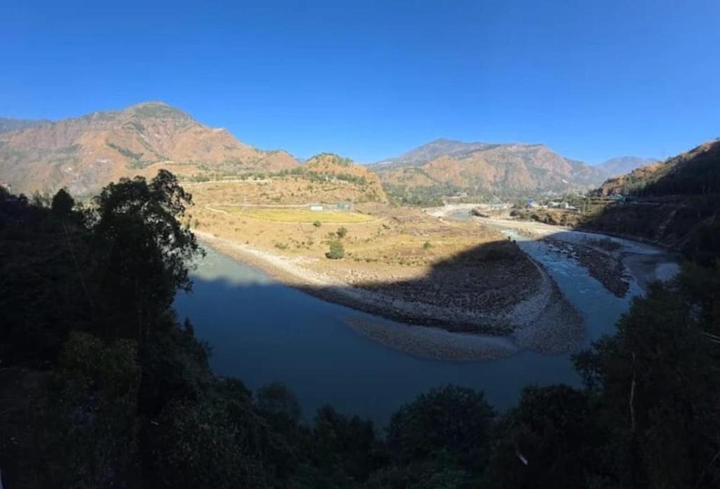 Una vista de un río con montañas al fondo. en PD Residency, en Duttnager