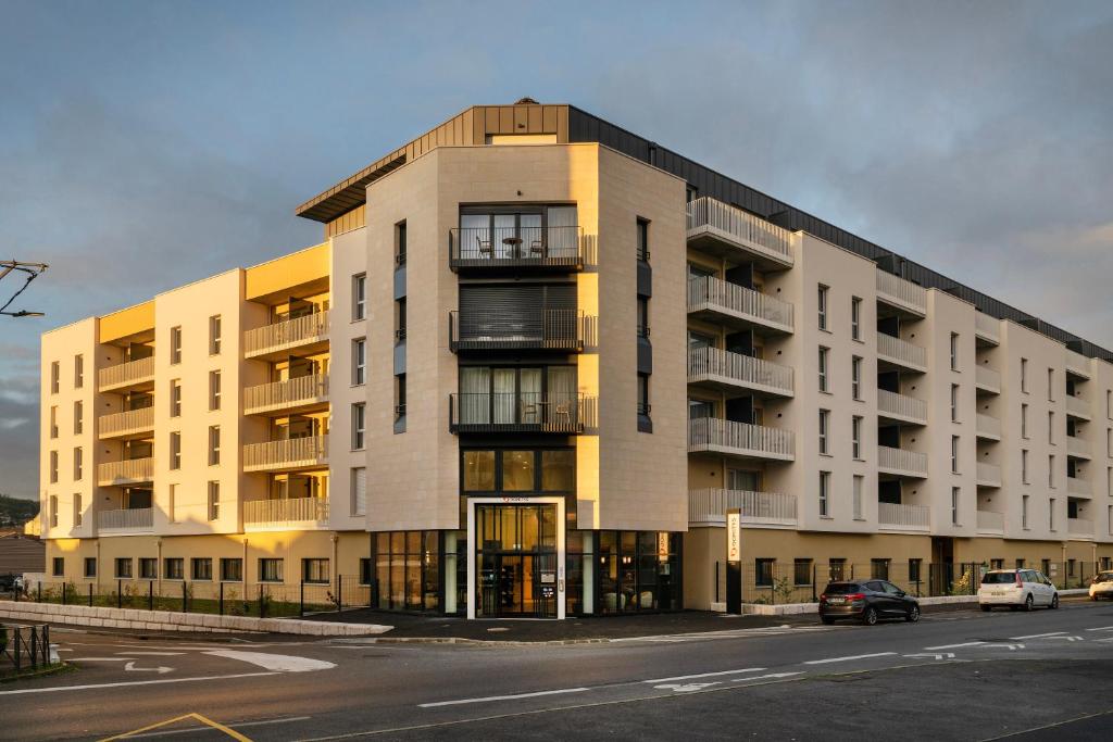 un grande edificio con auto parcheggiate di fronte di DOMITYS - Galia a Brive-la-Gaillarde