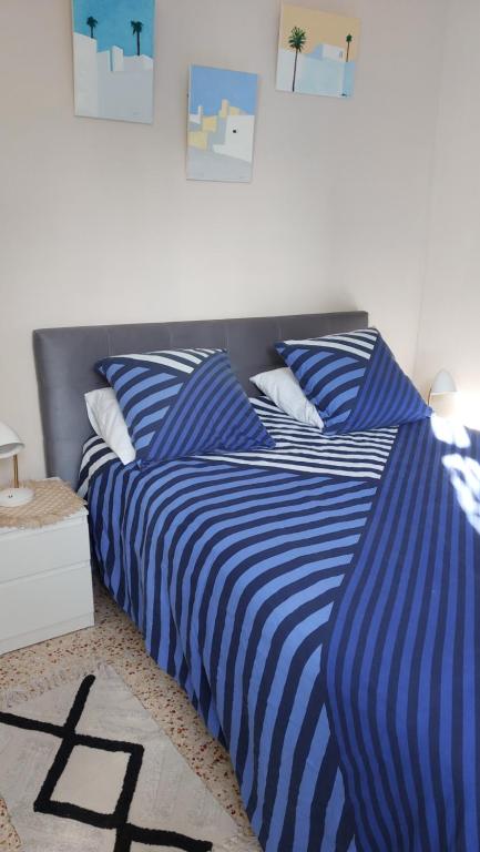 a bedroom with two beds with blue and white sheets at superbe appartement et son garage privé gratuit in Nîmes