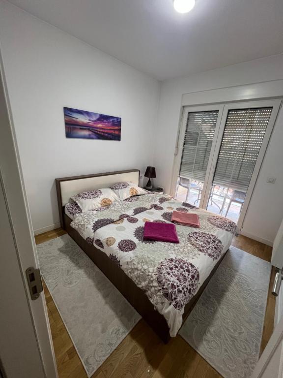 a bedroom with a bed with a comforter and pillows at Luxury & Green Apartments , near City Center, Free Parking in Pristina
