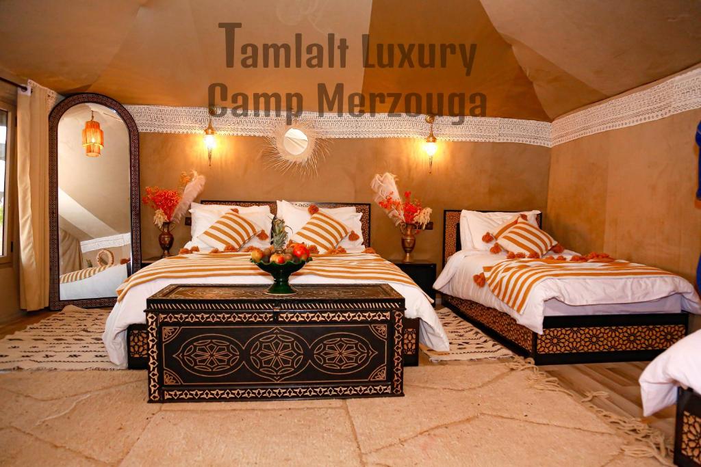 Postel nebo postele na pokoji v ubytování Tamlalt Luxury Camp Merzouga