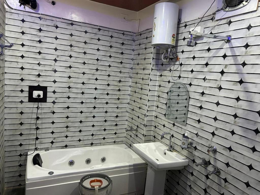Un baño blanco con bañera y lavabo. en mshotel Loharu, en Lohāru