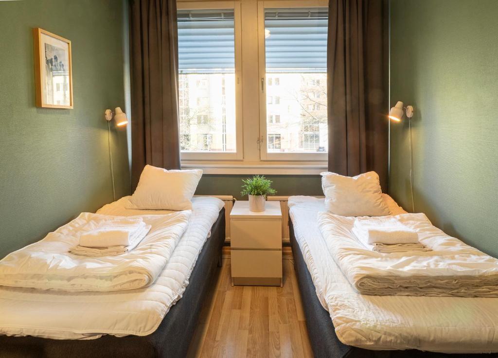 two beds in a room with a window at Göteborg Hostel in Gothenburg