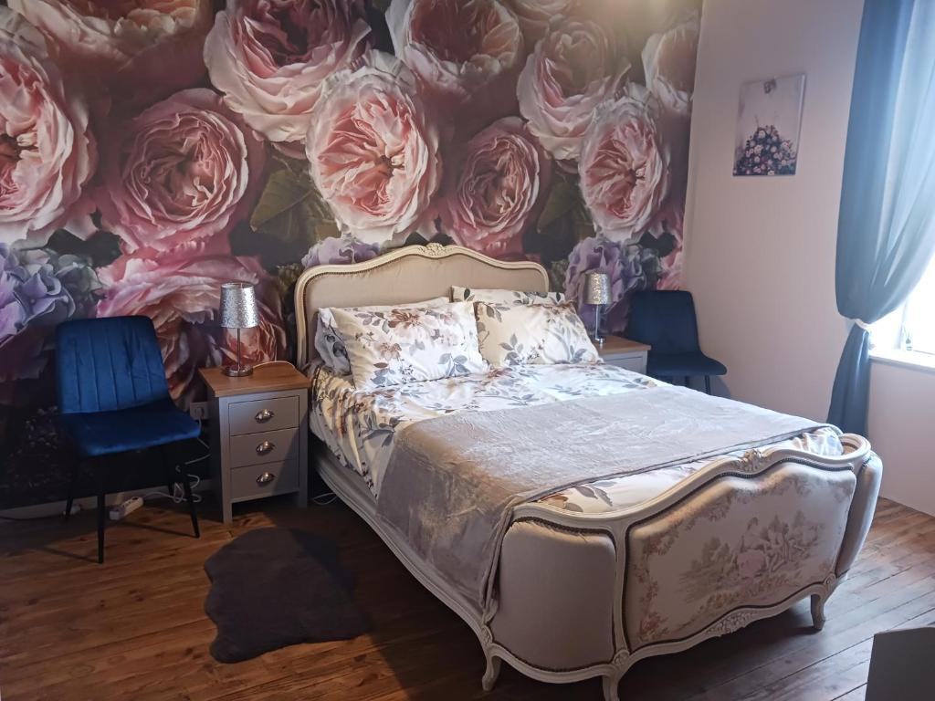 a bedroom with a bed and a wall of roses at Cherry Blossom House in Bujaleuf