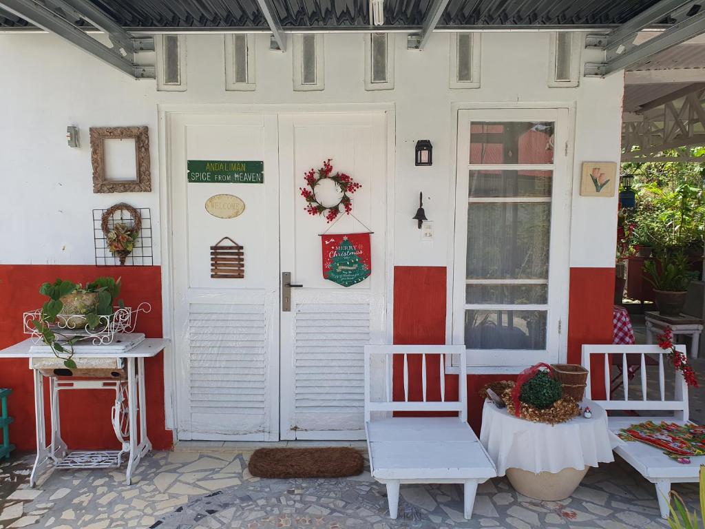 una porta d'ingresso di una casa con due sedie e un tavolo di Ruma Kaca Simanindo Bed&Breakfast ad Ambarita