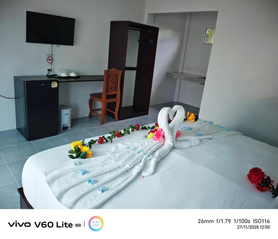 a white swan laying on top of a bed at Naranta House in Ko Raeng