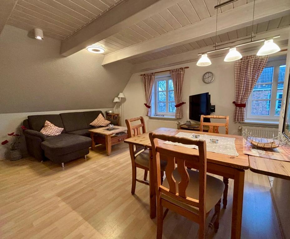 a living room with a table and a couch at Adlerhorst - Moderne 60 qm Wohnung mit Terrasse in Oevenum