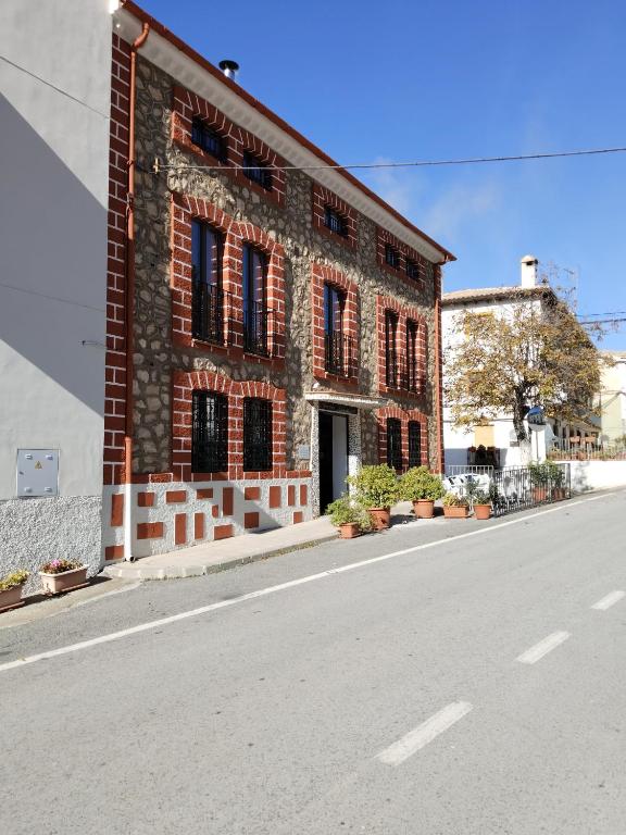 a brick building on the side of a street at Hostal el Ciervo in Burunchel
