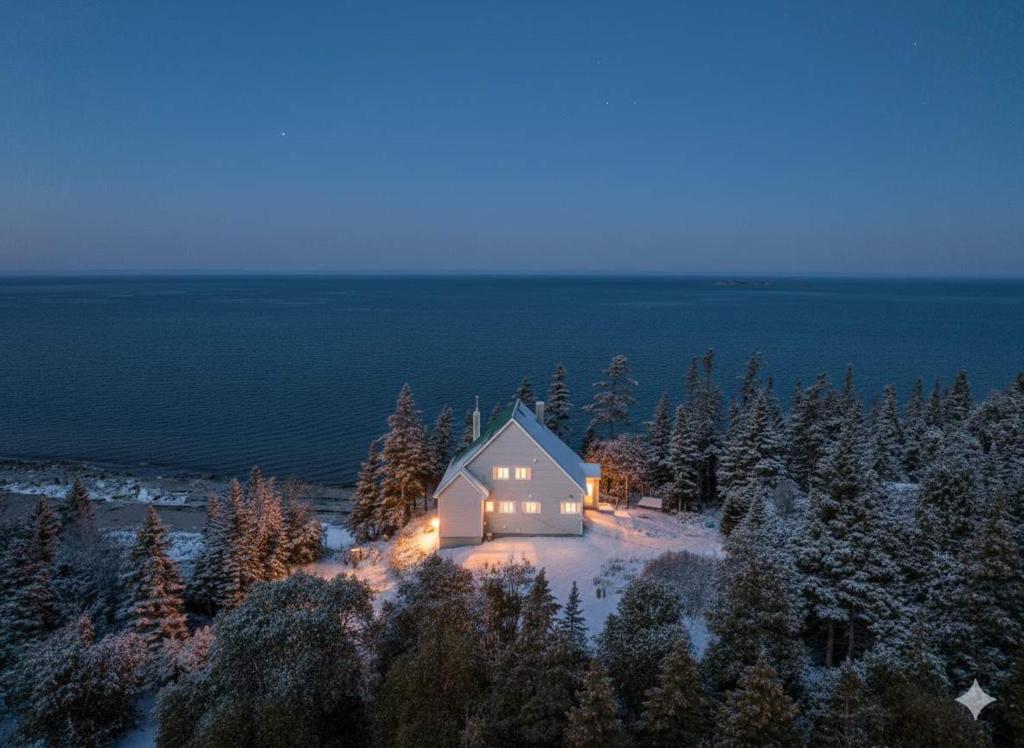 una casa su un'isola nella neve di notte di Spa Nature & Comfort - Chalet LRioux a Trois-Pistoles