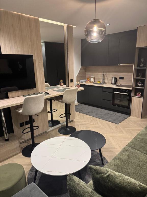 a kitchen and living room with a table and chairs at Apartments Lana in Mostar