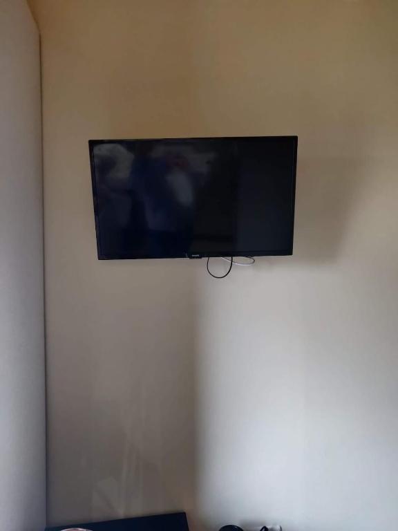 a flat screen tv hanging on a wall at Petit chalet avec piscine privée in Lumbin