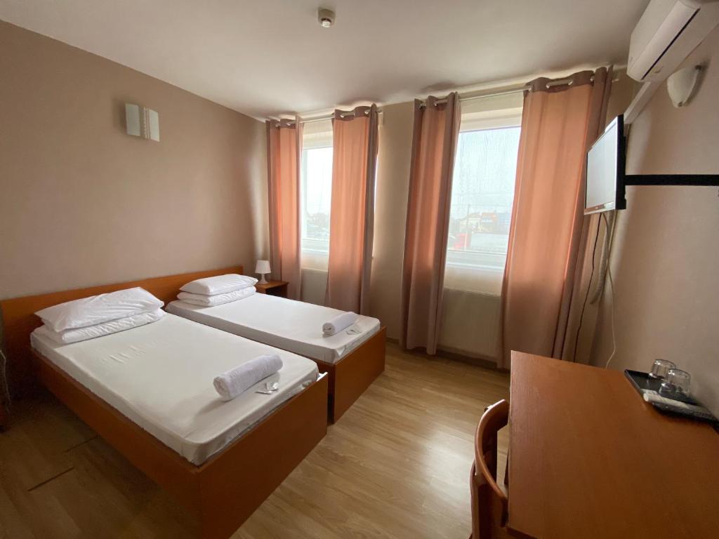 a hotel room with two beds and a television at Hotel Ferihegy in Vecsés