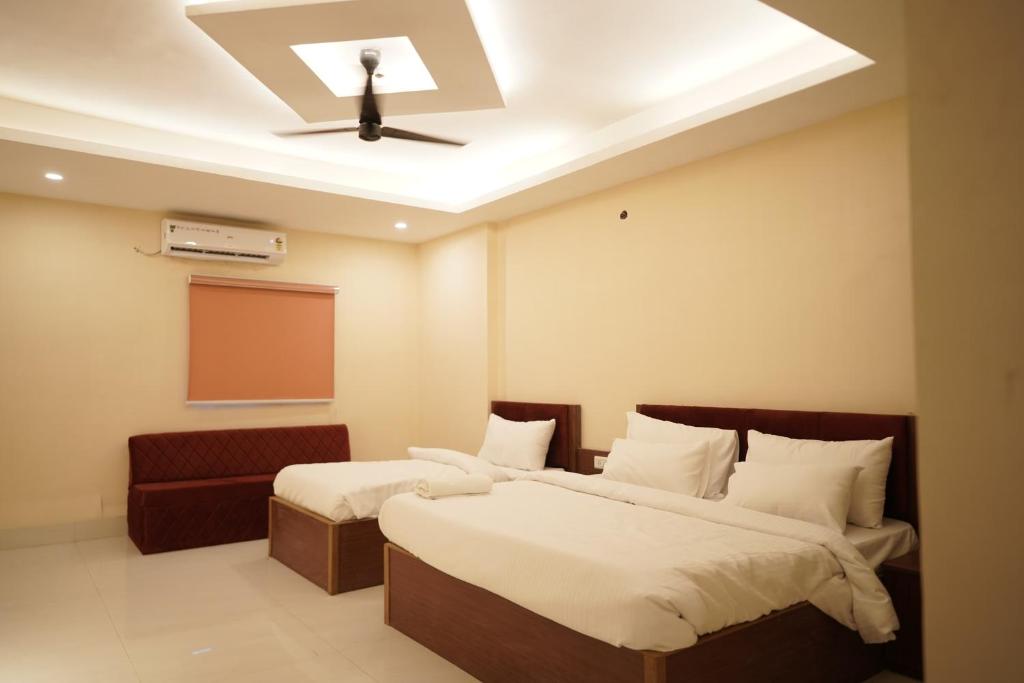 2 camas en una habitación con ventilador de techo en Hotel The Grand Ranjeet, en Indore