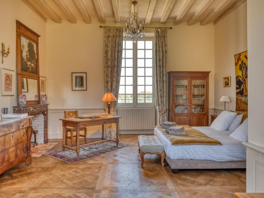 una sala de estar con una cama y una mesa en Le Petit Serrant - maison d'hôtes d'exception, en Bouchemaine