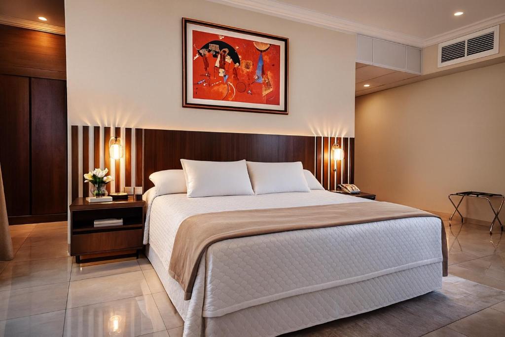 a bedroom with a bed and a painting on the wall at Hotel Maywa in Santa Cruz de la Sierra
