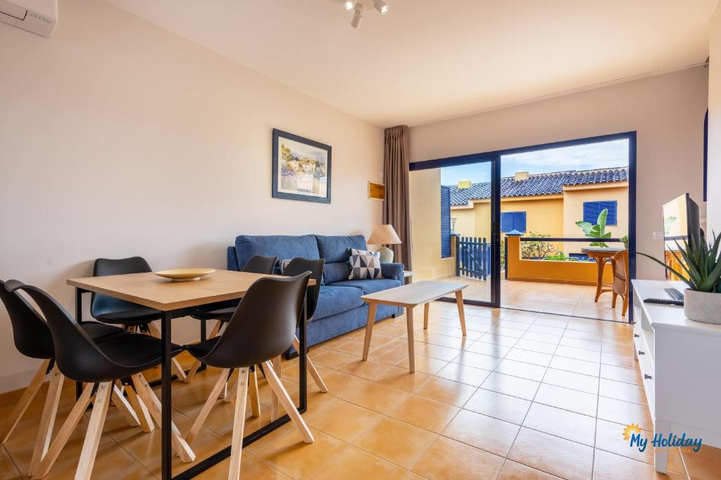 un salon avec un canapé bleu, une table et des chaises dans l'établissement Villa Meloneras III, à Maspalomas