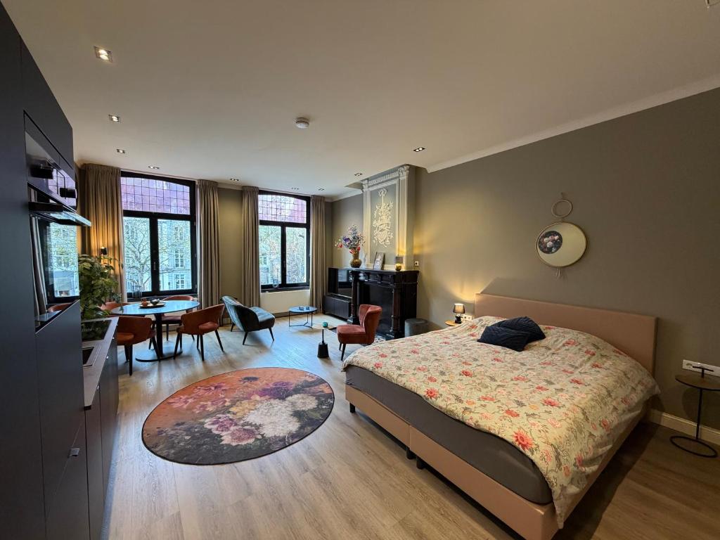 a bedroom with a bed and a table and chairs at Maastricht Suites - City Studio A in Maastricht