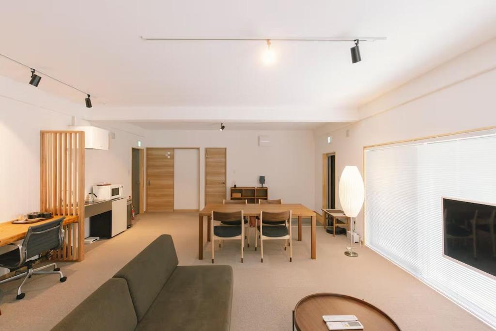 una sala de estar con un sofá y una mesa en Stay奥松阪, en Matsusaka
