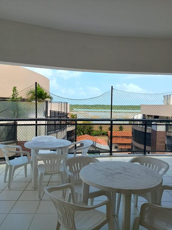 eine Terrasse mit Tischen und Stühlen auf einem Balkon in der Unterkunft Salinópolis Praia in Salinópolis