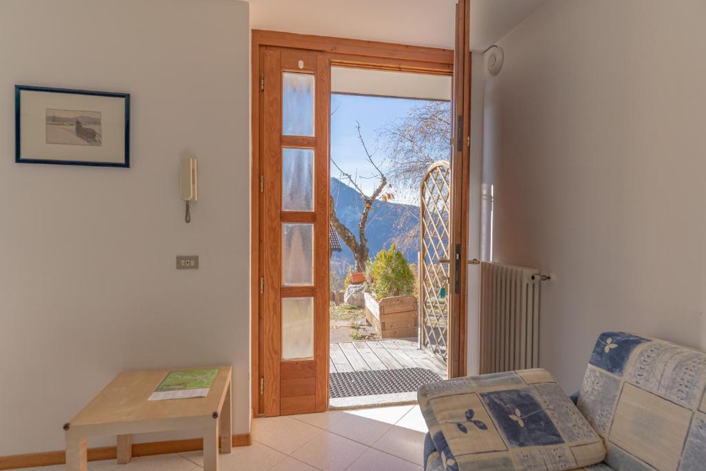a living room with a door open to a patio at Trilo La Rindela in Folgaria