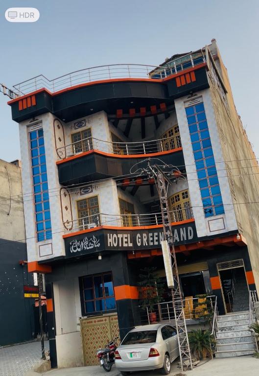 a hotel with a car parked in front of it at Green land hotel in Mingāora