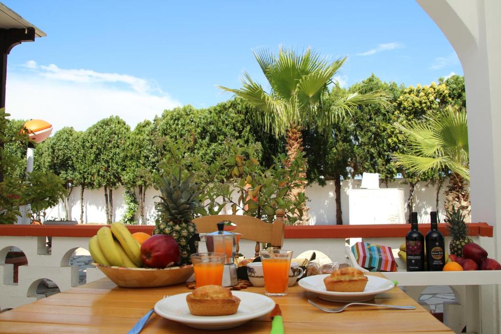 a table with food and fruit on a balcony at Villa Tony - Baia Verde Only Teenagers in Baia Verde