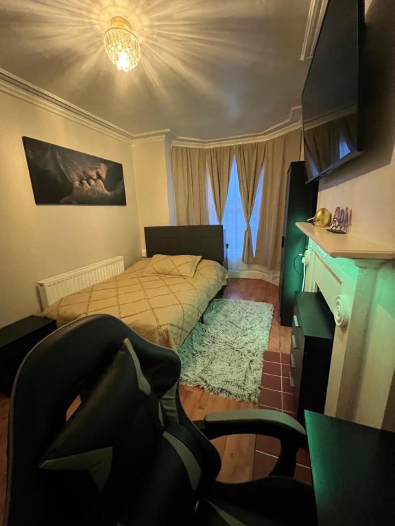 a bedroom with a bed and a desk and a chair at accommodation near Luton city centre in Luton