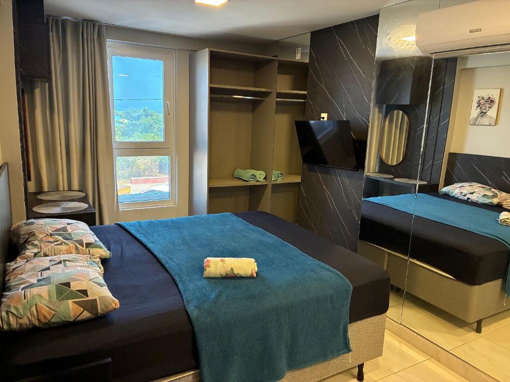 a bedroom with two beds with a blue blanket at Apartment 201 / Oceanfront / Mirrored Bed / Kitchen in João Pessoa