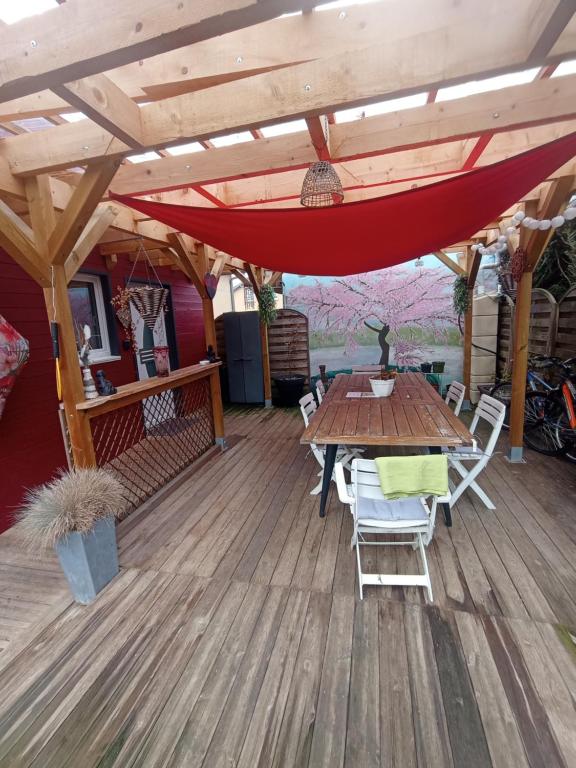 a wooden deck with a wooden table and chairs at Au Logis du Mont in Belfort