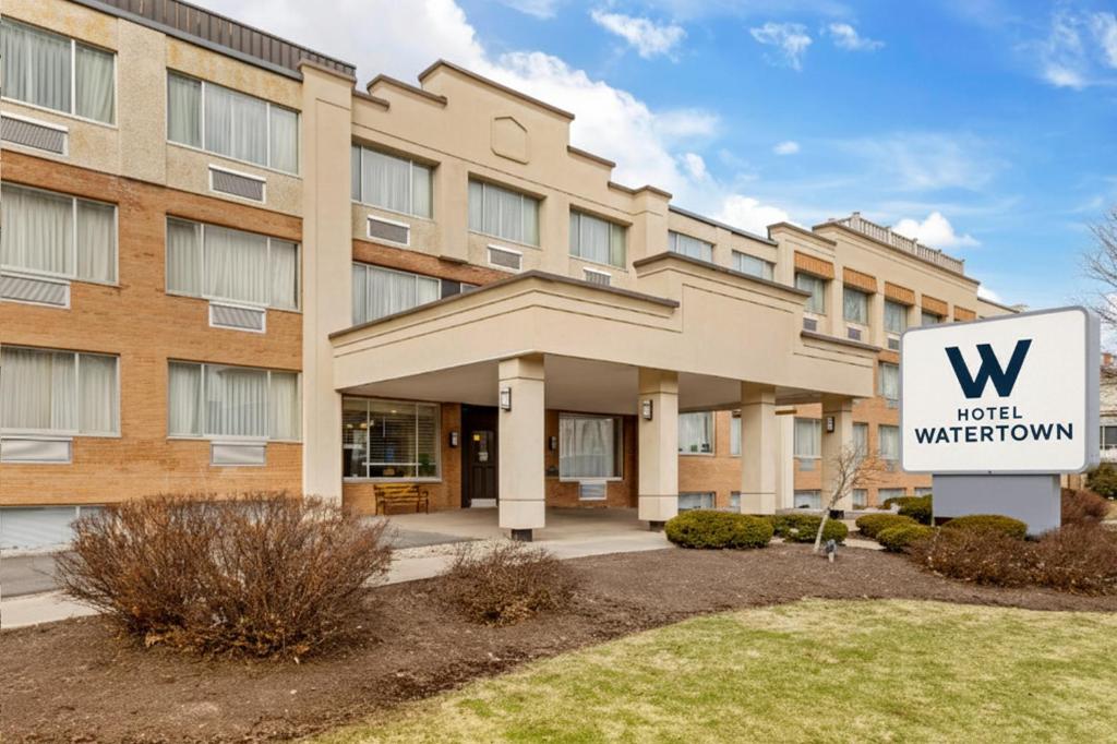 un edificio con un'insegna di un hotel di fronte di Hotel Watertown, Fort Drum a Watertown