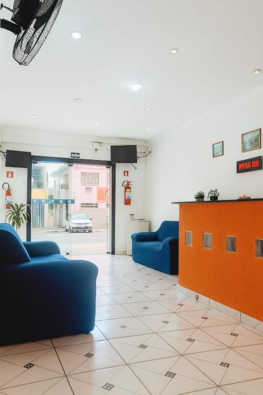ein Wartezimmer mit blauen Sofas und einem orangefarbenen Schrank in der Unterkunft Hotel Silveira in Guarapari