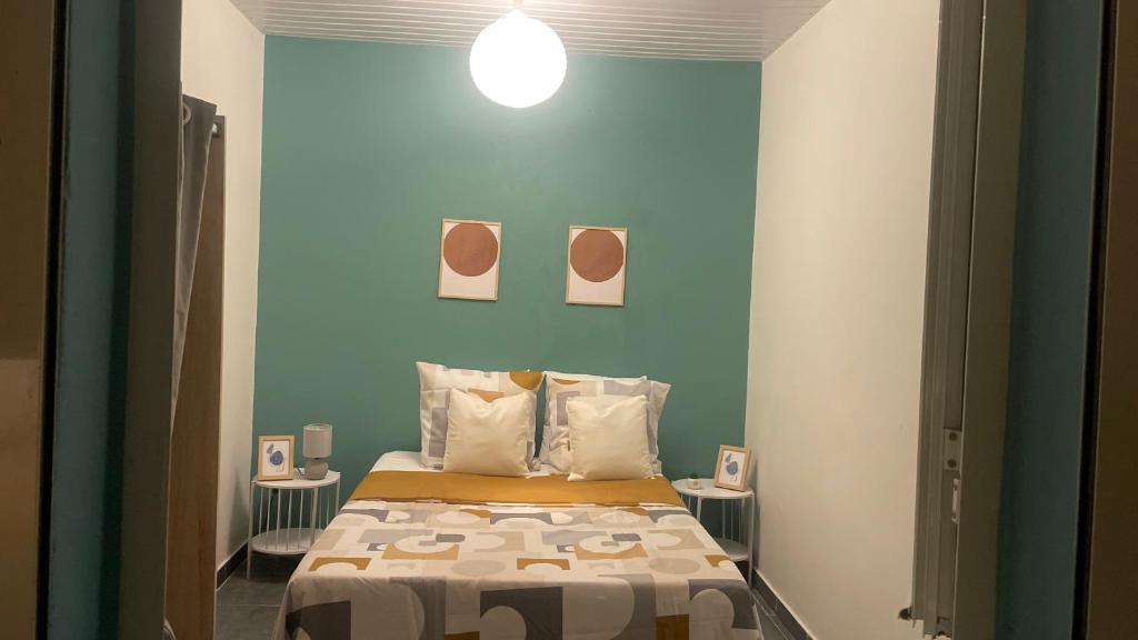 a bedroom with a bed with a blue wall at T3 moderne avec piscine proche de Family Plaza in Matoury
