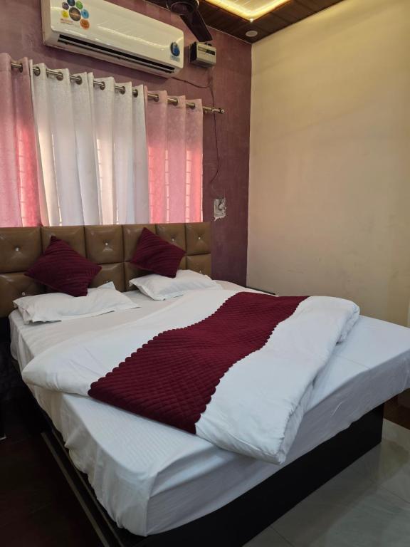 uma cama com um cobertor vermelho e branco em Hotel Mestica Classic em Dehradun Airport